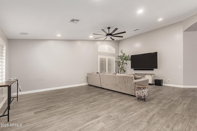 living area with ceiling fan, visible vents, baseboards, and light wood finished floors