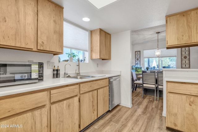 kitchen with light brown cabinets, hanging light fixtures, and stainless steel dishwasher