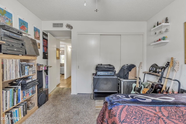 bedroom with carpet flooring, a closet, and a textured ceiling