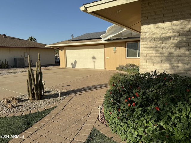 exterior space with cooling unit and a garage