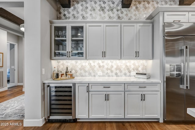 bar featuring wine cooler, white cabinetry, and stainless steel built in refrigerator