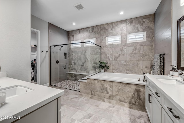 bathroom with vanity and shower with separate bathtub