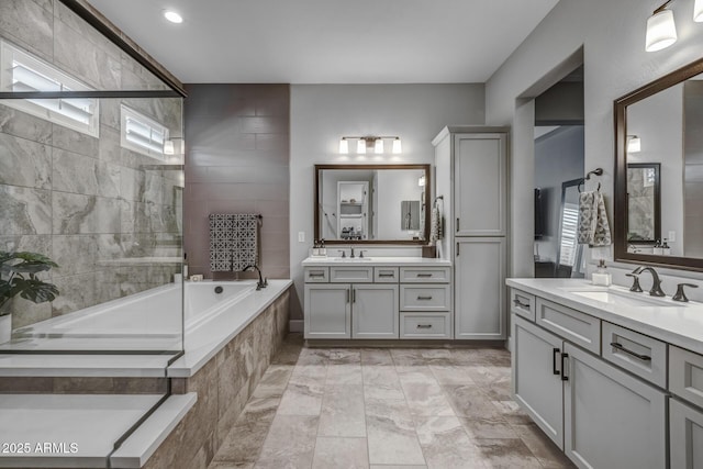 bathroom with a relaxing tiled tub and vanity