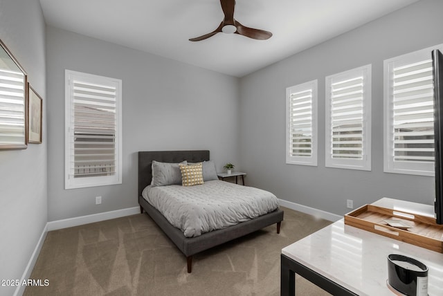 carpeted bedroom with multiple windows and ceiling fan