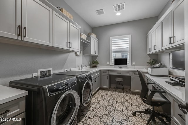 clothes washing area featuring cabinets, sink, and washing machine and dryer