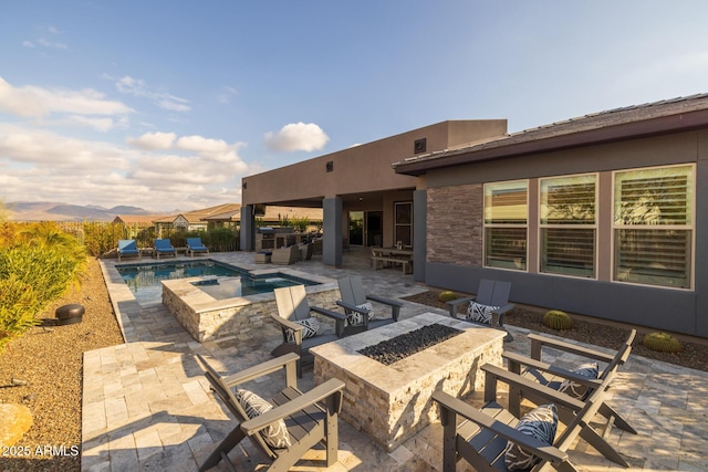 view of patio / terrace with a mountain view, a pool with hot tub, and a fire pit