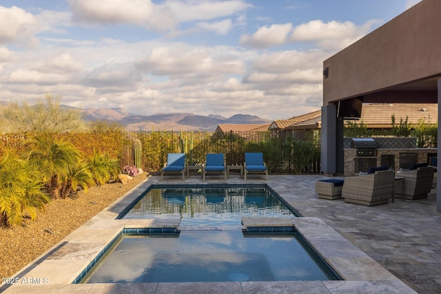 view of swimming pool with exterior kitchen, an in ground hot tub, grilling area, and a patio