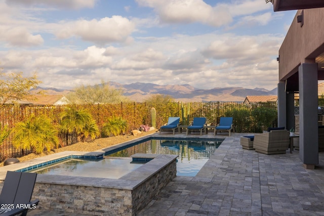 view of swimming pool featuring a mountain view, a patio, and an in ground hot tub