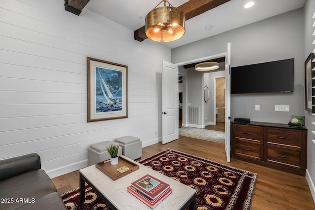 living room with hardwood / wood-style flooring and beam ceiling