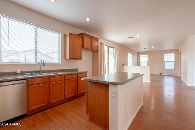 kitchen with a sink, dishwasher, recessed lighting, light wood-type flooring, and a kitchen island