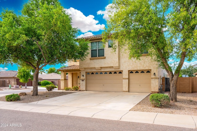 view of front of house featuring a garage, fence, stucco siding, a tiled roof, and concrete driveway