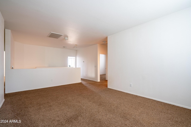 spare room featuring baseboards, visible vents, and carpet