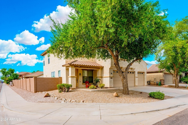 view of front of property featuring fence, a tile roof, a garage, stucco siding, and concrete driveway