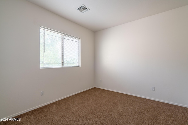 spare room with visible vents, carpet, and baseboards