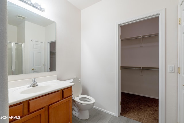 full bath featuring a walk in closet, a shower stall, toilet, and visible vents