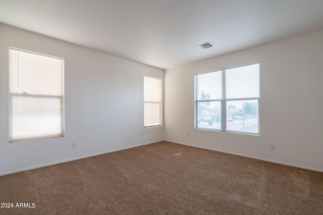 spare room with visible vents, carpet flooring, and baseboards