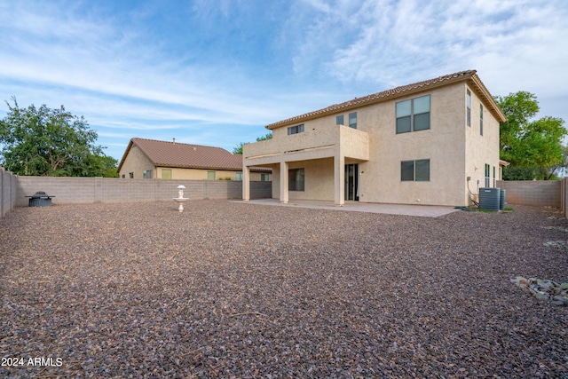 rear view of property with central air condition unit, a fenced backyard, a patio area, and stucco siding