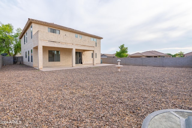 back of property with a fenced backyard, a patio area, and stucco siding