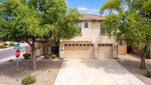 view of front of house featuring an attached garage, stucco siding, driveway, and a tile roof