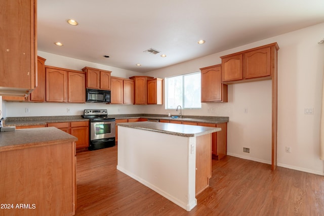 kitchen with black microwave, recessed lighting, light wood finished floors, and stainless steel electric range