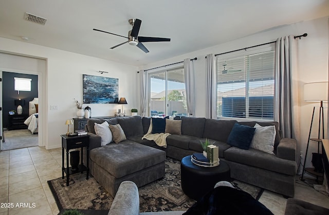 living room with ceiling fan, visible vents, baseboards, and light tile patterned flooring