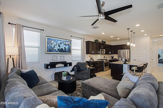 living room with a wealth of natural light, visible vents, and recessed lighting