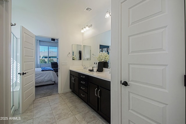 bathroom with ensuite bathroom, double vanity, a sink, and a shower stall