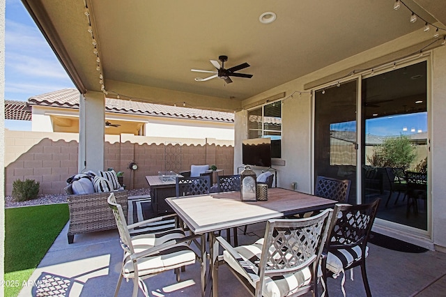 view of patio with a ceiling fan, outdoor dining space, and fence