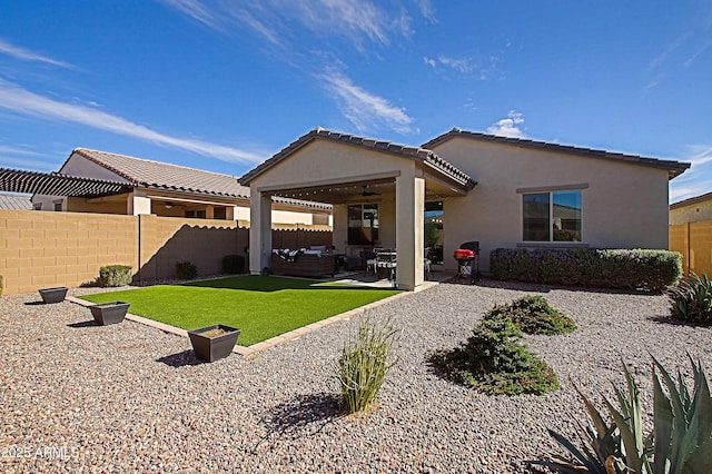 back of property featuring a yard, a patio area, fence, and stucco siding