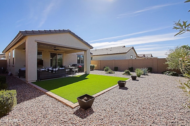 rear view of house with an outdoor living space with a fire pit, a fenced backyard, ceiling fan, a patio area, and stucco siding