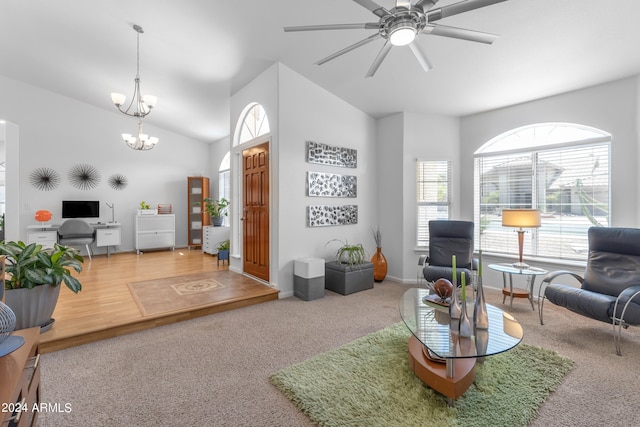 living room with ceiling fan with notable chandelier, vaulted ceiling, and hardwood / wood-style flooring