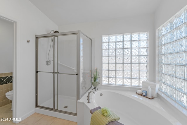 bathroom featuring toilet, tile patterned floors, and shower with separate bathtub