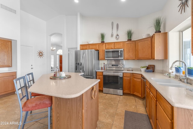 kitchen featuring a center island, high vaulted ceiling, stainless steel appliances, and sink