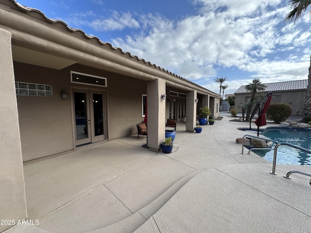 view of swimming pool featuring french doors and a patio area