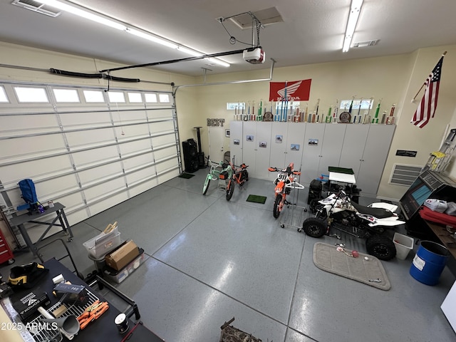 garage with a garage door opener and visible vents