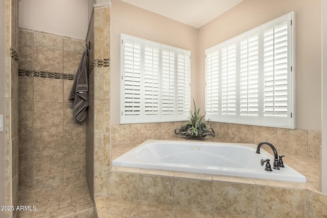 bathroom featuring tiled shower and a bath