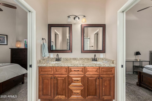 ensuite bathroom featuring double vanity, connected bathroom, a sink, and ceiling fan