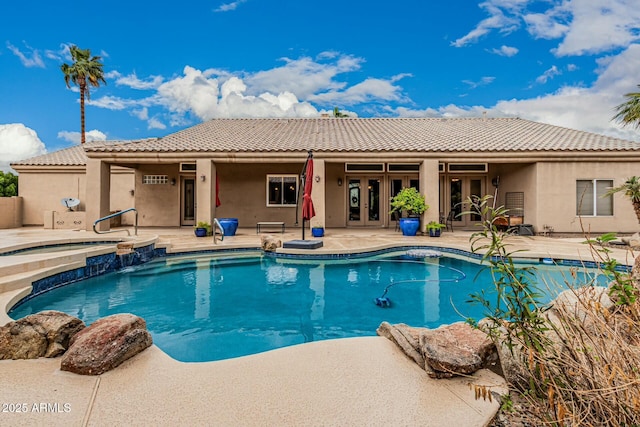 view of swimming pool with a pool with connected hot tub, french doors, and a patio