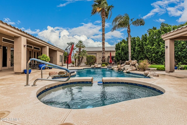 view of swimming pool with an in ground hot tub, a patio, and french doors