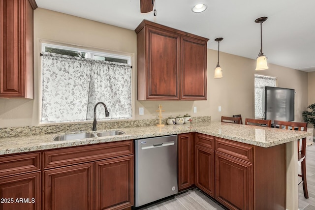 kitchen featuring dishwasher, a kitchen breakfast bar, a peninsula, light stone countertops, and a sink