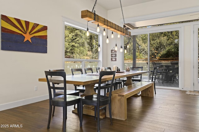 dining space with hardwood / wood-style flooring and baseboards