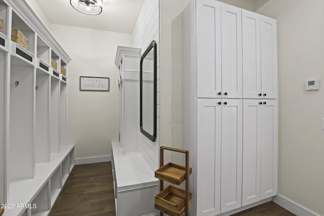 mudroom with dark wood-style flooring and baseboards