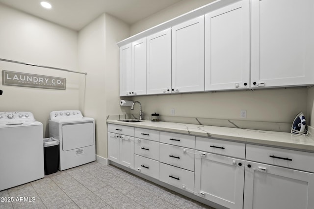 laundry room with cabinet space, baseboards, independent washer and dryer, a sink, and recessed lighting