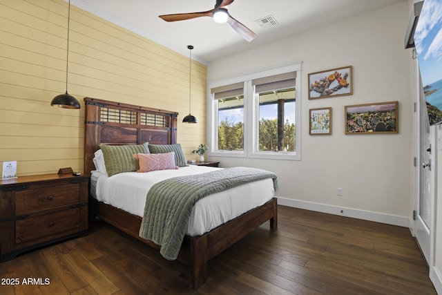 bedroom featuring dark wood-style flooring, visible vents, wood walls, ceiling fan, and baseboards