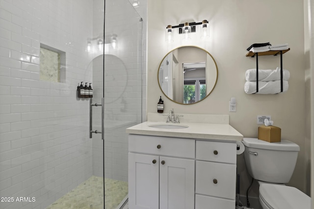 full bathroom featuring a tile shower, vanity, and toilet