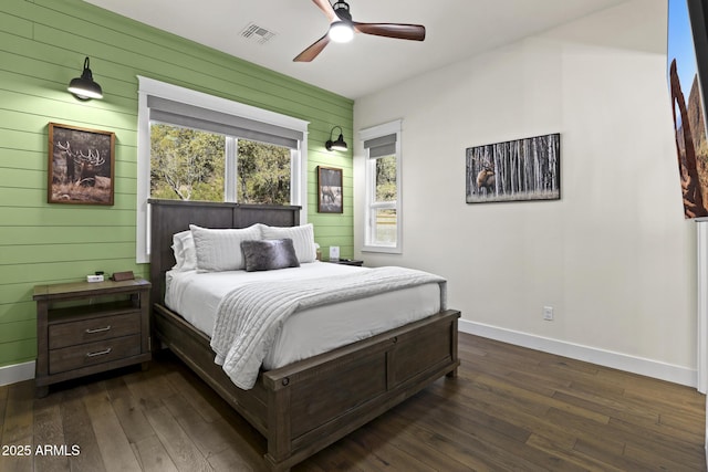 bedroom featuring visible vents, dark wood finished floors, baseboards, and ceiling fan