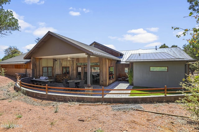 back of property with metal roof and a standing seam roof