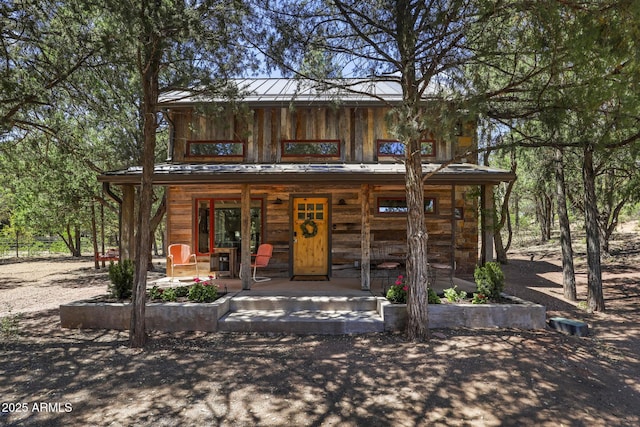 view of front of house with a standing seam roof, a porch, and metal roof