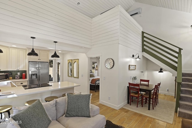 kitchen with light wood finished floors, tasteful backsplash, appliances with stainless steel finishes, cream cabinets, and light countertops