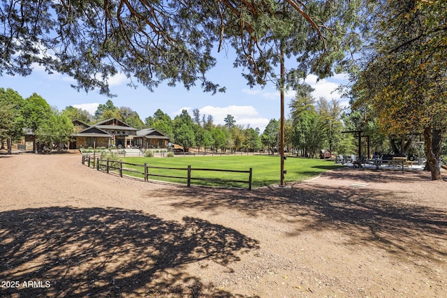 view of community featuring a lawn and fence